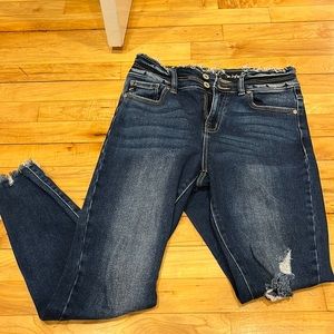 Dark wash denim skinny jeans with one rip in the knee